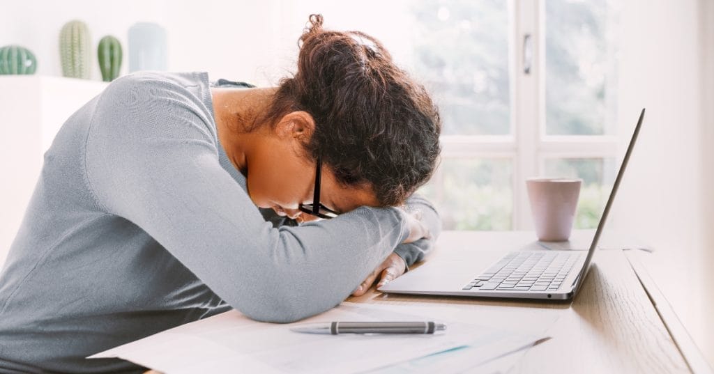 woman laying on her arms with laptop in front of her