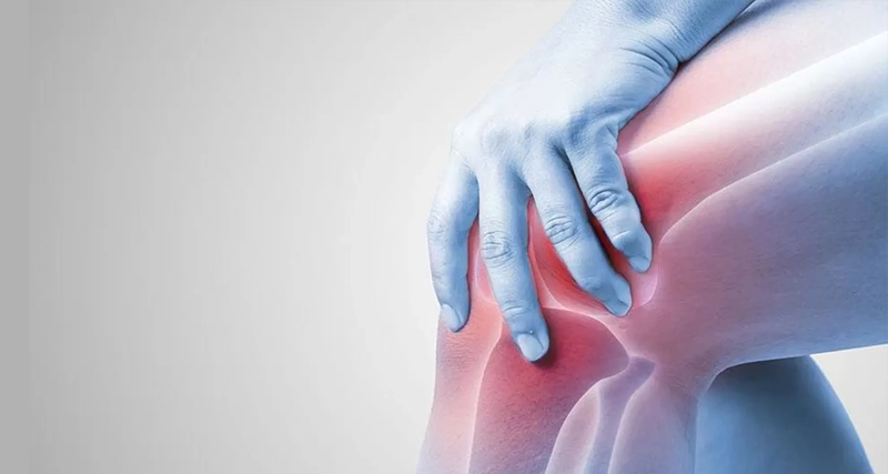 Person holding swollen knee with visible inflammation, indicating pain or complications from a Baker’s cyst.
