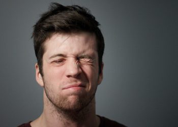 Man with uneven facial expression due to muscle weakness, a common sign of Bell’s palsy affecting one side of the face.