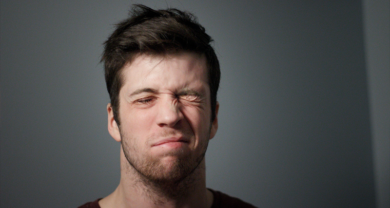 Man with uneven facial expression due to muscle weakness, a common sign of Bell’s palsy affecting one side of the face.