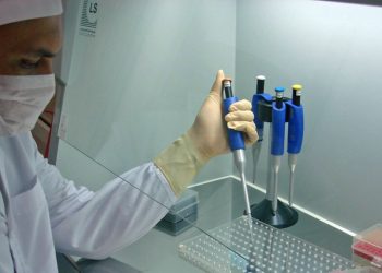 Scientist working in a lab with pipettes, representing research and testing related to bird flu in South Africa.