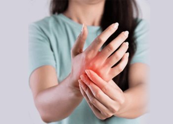 Woman holding inflamed hand with visible redness, representing skin irritation or early signs of a boil.