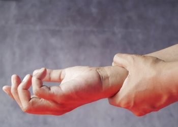 Person holding their injured wrist in pain
