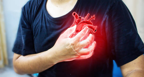 Person clutching chest with digital heart overlay indicating cardiac distress