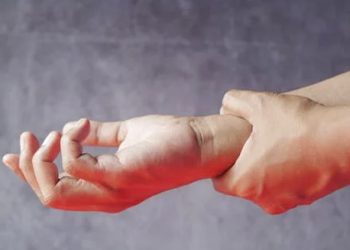 Person holding wrist in pain
