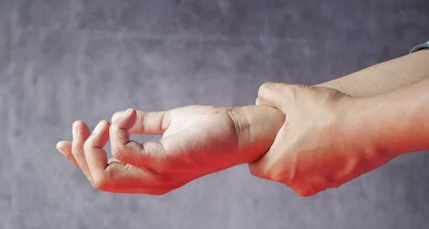 Person holding wrist in pain