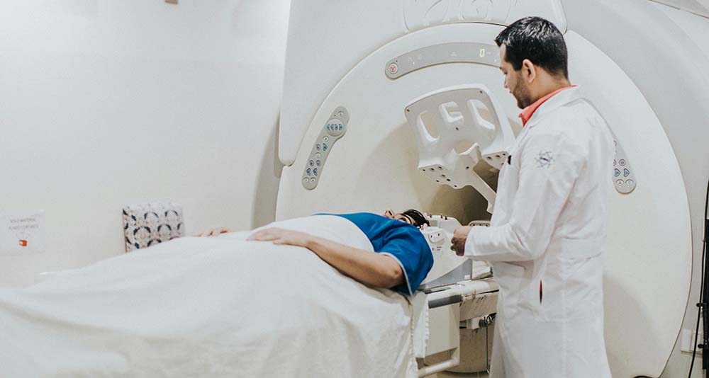 Patient undergoing MRI brain scan with technician in hospital
