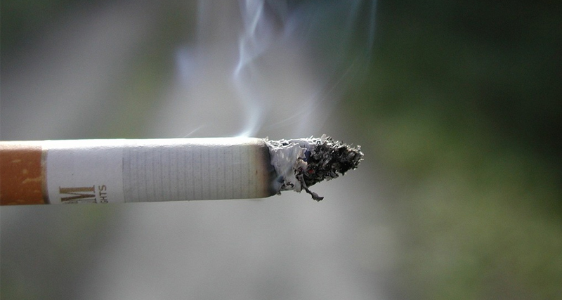 Close-up of a burning cigarette, symbolising smoking as a major risk factor for bladder cancer.