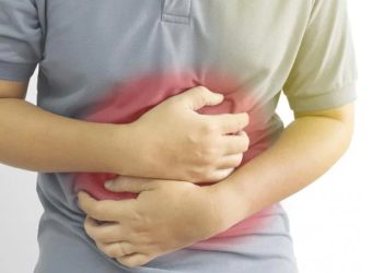 Person clutching abdomen to indicate bowel incontinence pain and discomfort