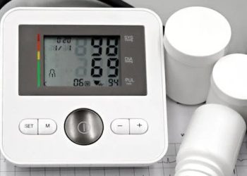 Blood pressure monitor and medication bottles on an ECG printout