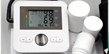 Blood pressure monitor and medication bottles on an ECG printout