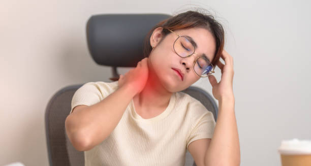 Woman experiencing neck pain, touching the back of her neck