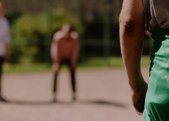 Person with elbow injury standing on a sports court