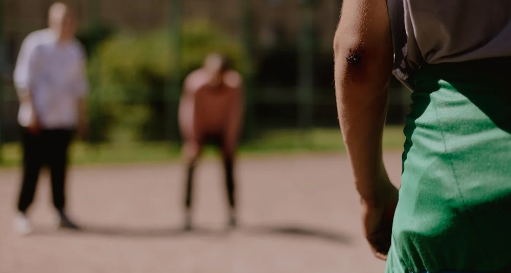 Person with elbow injury standing on a sports court