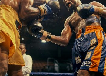 Boxers exchanging punches during a fight, highlighting potential rib injuries