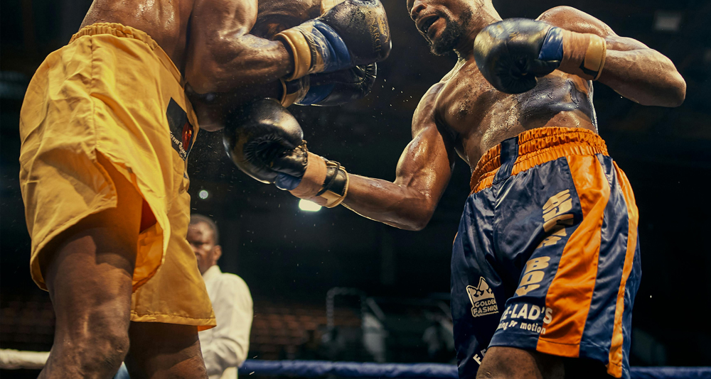 Boxers exchanging punches during a fight, highlighting potential rib injuries