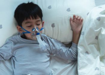 Child sleeping with oxygen mask due to severe bronchiolitis