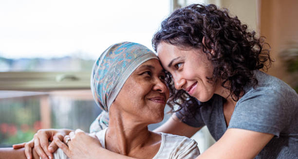 Smiling woman with headscarf embraced by supportive young woman