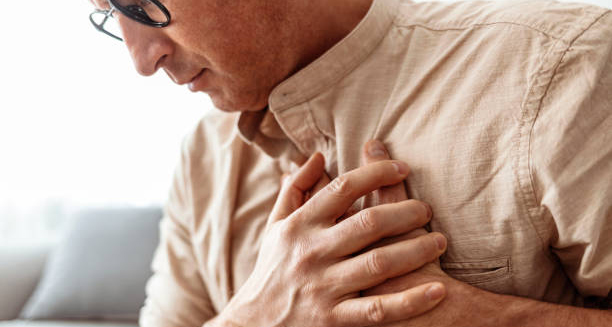 Man clutching his chest in discomfort, possibly due to cardiomyopathy
