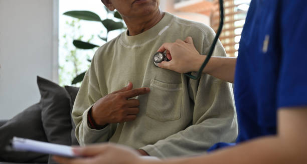 Doctor using stethoscope to examine patient's chest during heart check-up