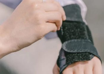 Person adjusting a wrist brace for carpal tunnel syndrome