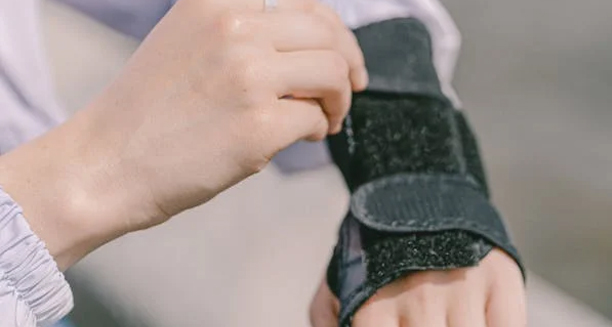 Person adjusting a wrist brace for carpal tunnel syndrome