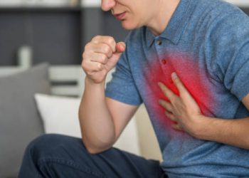 Man coughing with hand on chest showing signs of discomfort