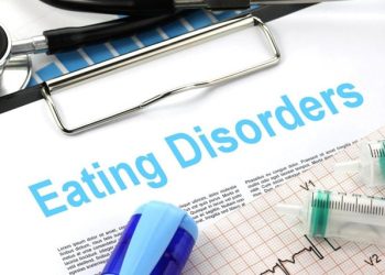 Medical chart with the words “Eating Disorders” surrounded by stethoscope, syringe, and ECG, symbolising clinical diagnosis of binge eating disorder.