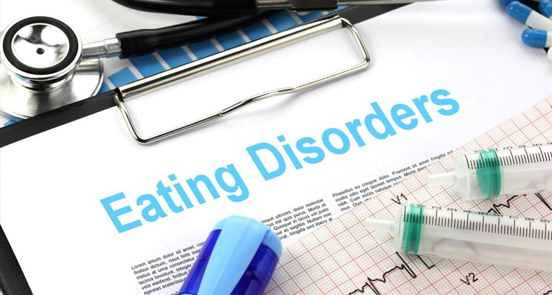 Medical chart with the words “Eating Disorders” surrounded by stethoscope, syringe, and ECG, symbolising clinical diagnosis of binge eating disorder.