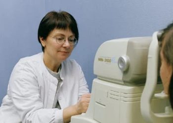 Eye doctor performing cataract test on adult patient