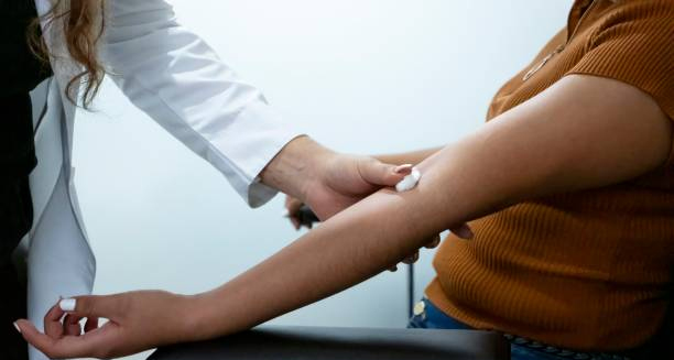 Medical professional examining a patient's arm for signs of cellulitis