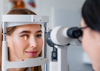 Woman undergoing an eye examination using a slit lamp