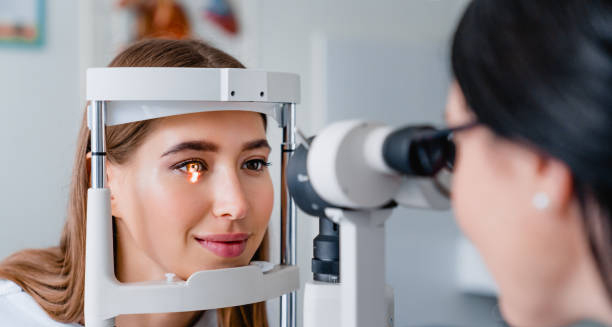 Woman undergoing an eye examination using a slit lamp