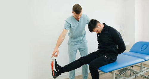 Physiotherapist assessing a patient's leg movement during examination