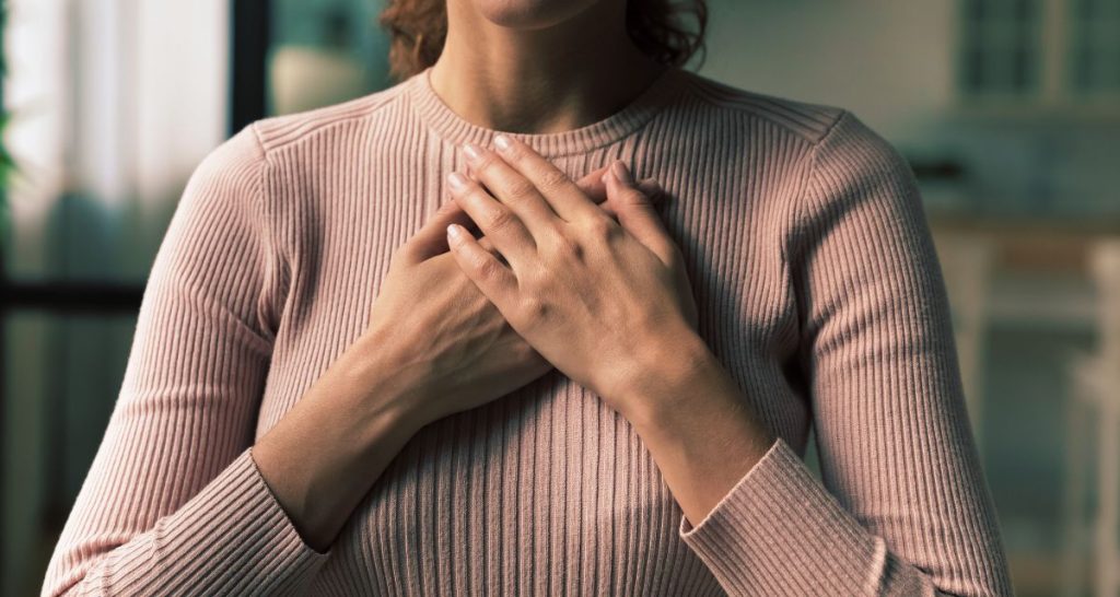 Woman holding her chest during a panic attack