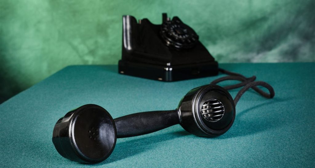 Old-fashioned telephone with receiver off the hook