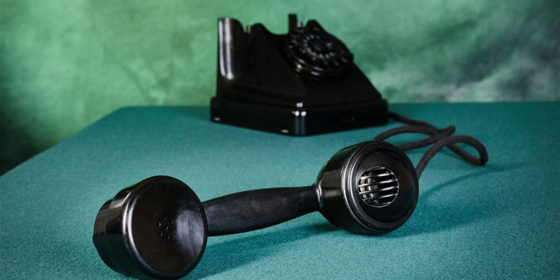 Old-fashioned telephone with receiver off the hook