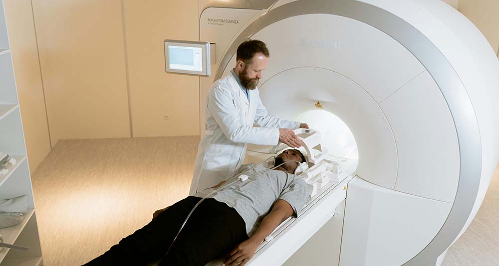 Doctor discussing brain scan results with patient near MRI machine
