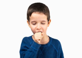Young boy in a blue shirt coughing, illustrating early symptoms of bronchiolitis
