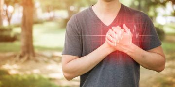 Man clutching chest with ECG line overlay indicating heart rhythm