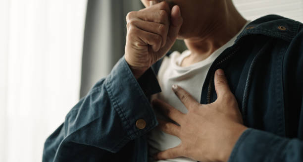 Person coughing and holding chest, indicating discomfort
