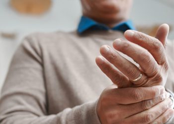 Man holding his hand in pain from a suspected broken finger
