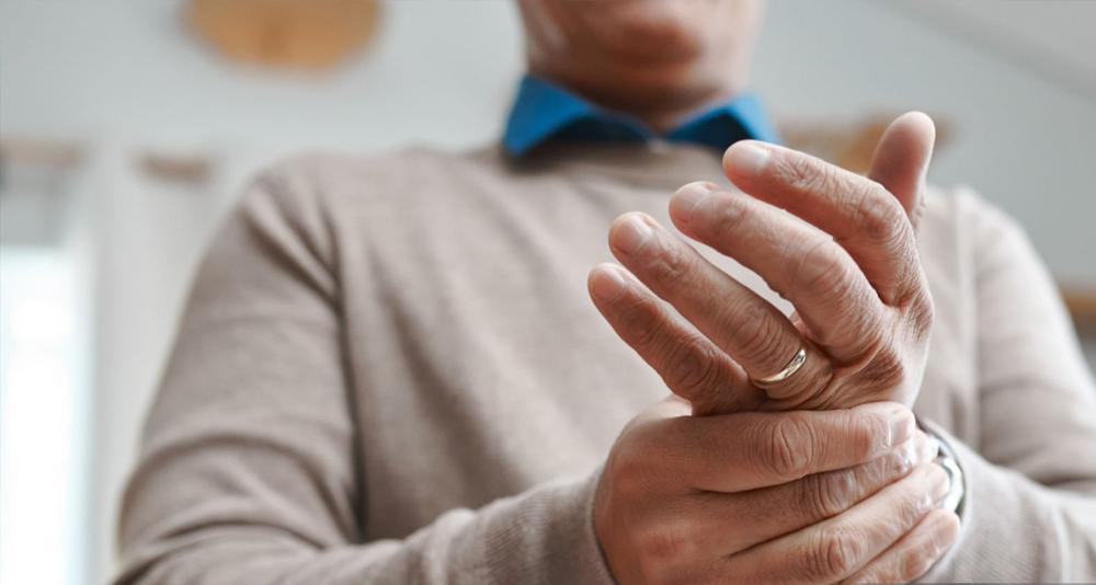 Man holding his hand in pain from a suspected broken finger