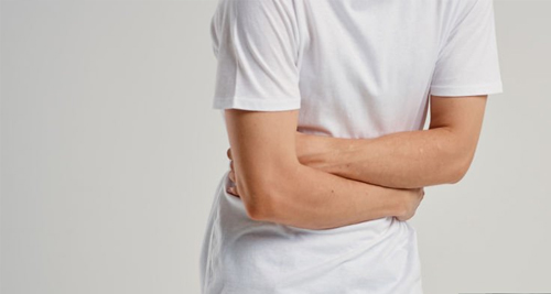 Person clutching their side in pain, possibly due to a broken rib