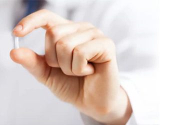 Hand holding a small medical suppository