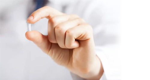 Hand holding a small medical suppository