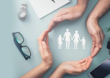 Hands forming a protective circle around a family icon, symbolising care, stability, and treatment support for bipolar disorder.