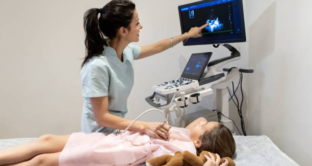 Healthcare professional performing an ultrasound on a young girl to monitor cardiomyopathy