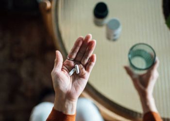 Person holding tablets and a glass of water