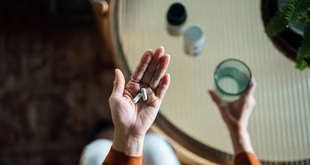 Person holding tablets and a glass of water